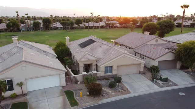 an aerial view of a house with garden space and lake view in back