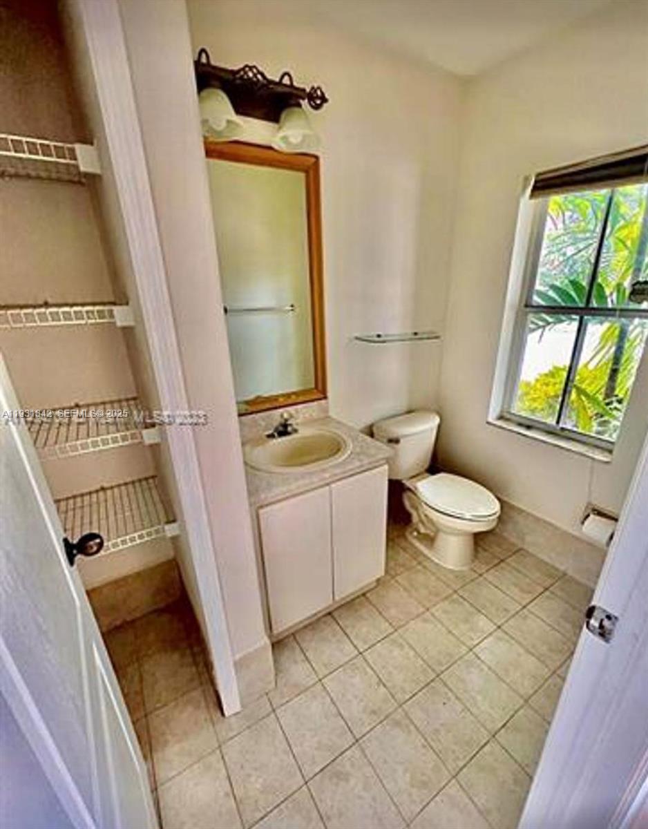 16972 Southwest 33rd Court, Unit 16972 Miramar, FL 33027 - Photo 14 of 15 a bathroom with a granite countertop toilet sink and mirror