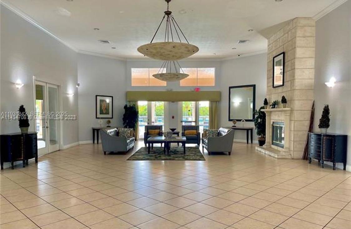 16972 Southwest 33rd Court, Unit 16972 Miramar, FL 33027 - Photo 7 of 15 a living room with fireplace furniture and a chandelier