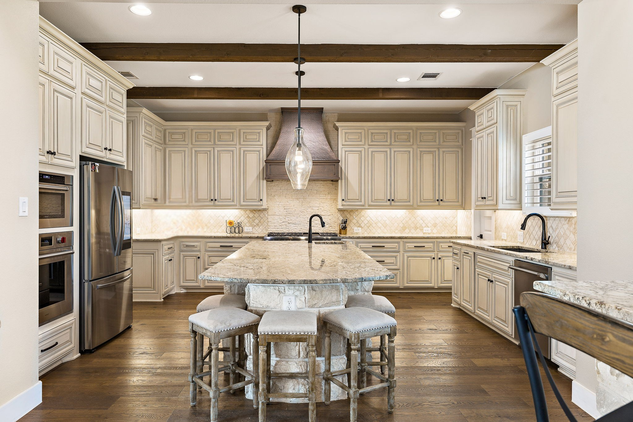 117 Covington Cove Georgetown, TX 78628 - Photo 11 of 40 Kitchen featuring cream cabinetry, decorative backsplash, beam ceiling, stainless steel appliances, and recessed lighting