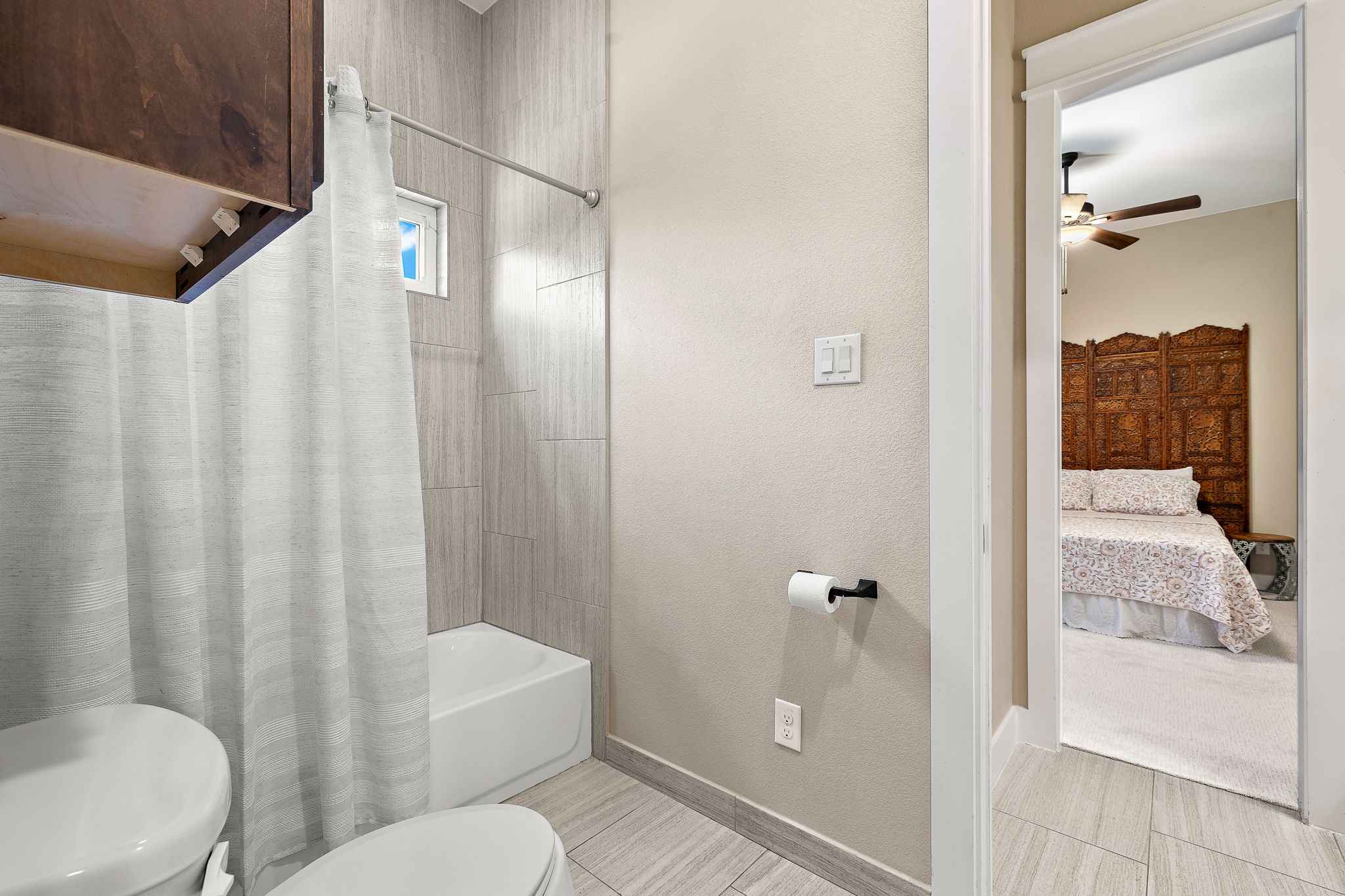 117 Covington Cove Georgetown, TX 78628 - Photo 24 of 40 Ensuite bathroom featuring ceiling fan, shower / bathtub combination with curtain, and a textured wall