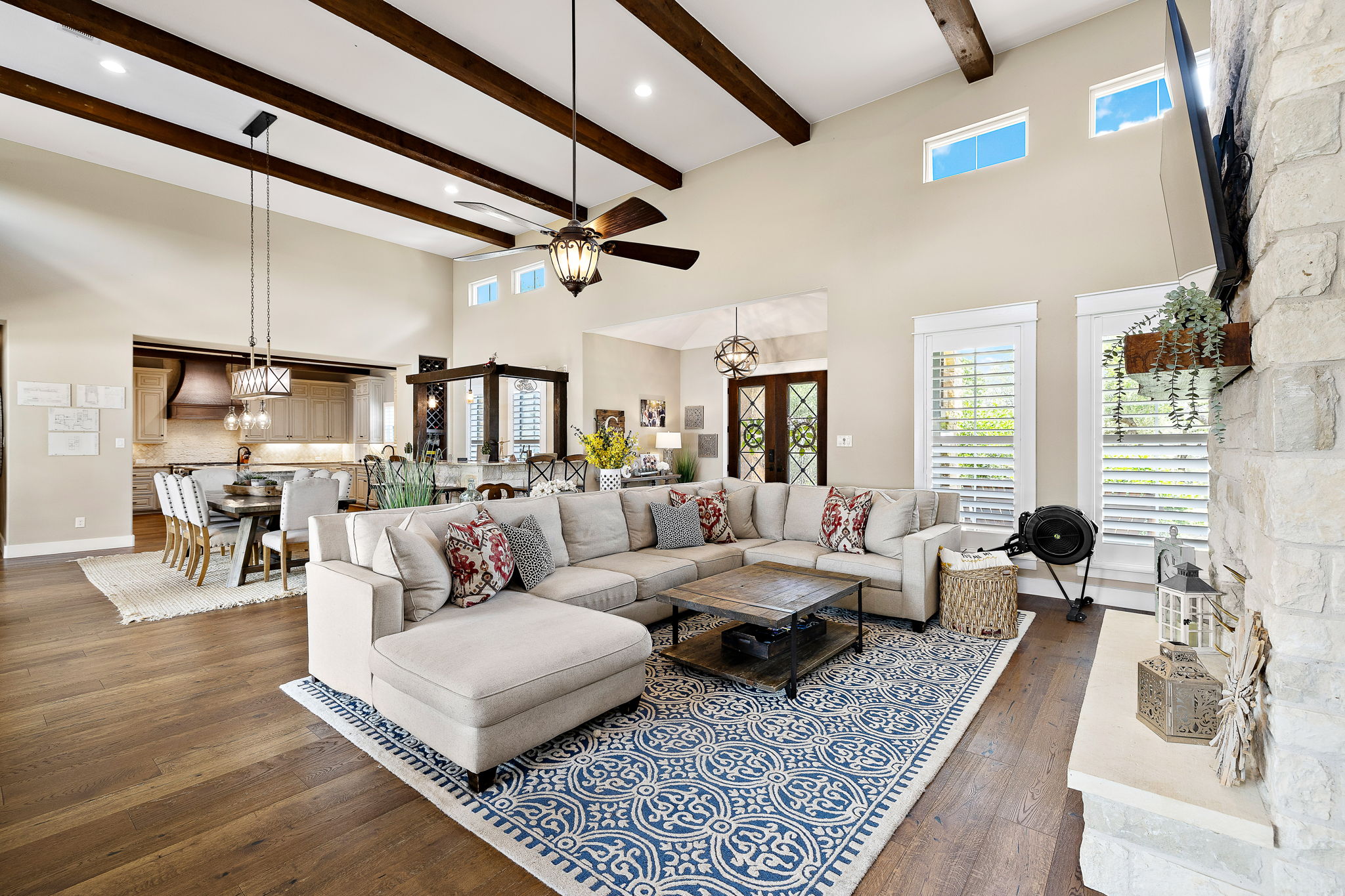117 Covington Cove Georgetown, TX 78628 - Photo 7 of 40 Living room with dark wood finished floors, a ceiling fan, a towering ceiling, beam ceiling, and a chandelier
