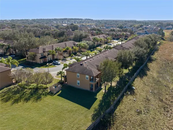 an aerial view of residential houses with outdoor space and trees