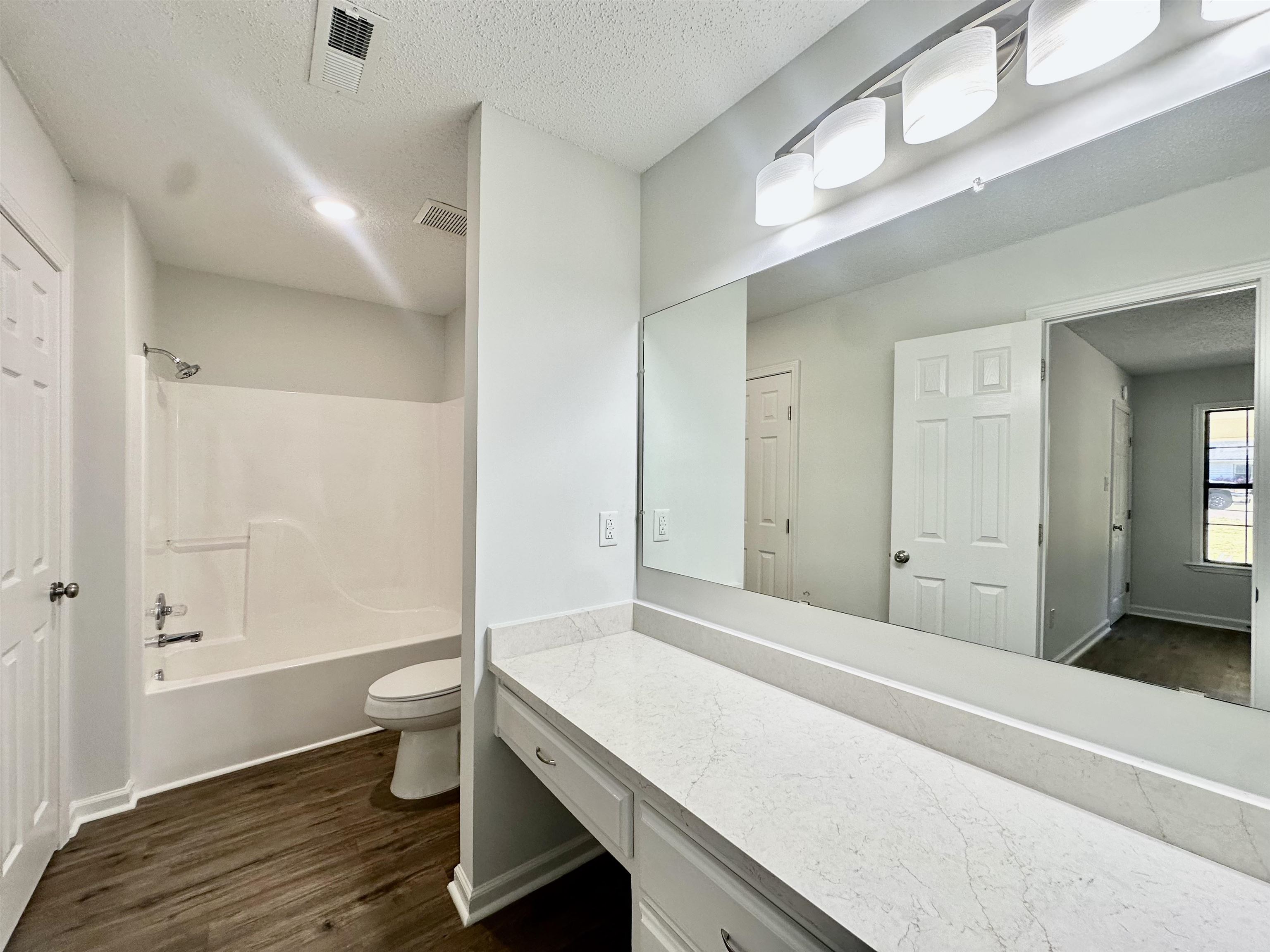 249 Mignon Road Atoka, TN 38004 - Photo 24 of 28 Bathroom with dark wood finished floors, a textured ceiling, shower combination, and vanity