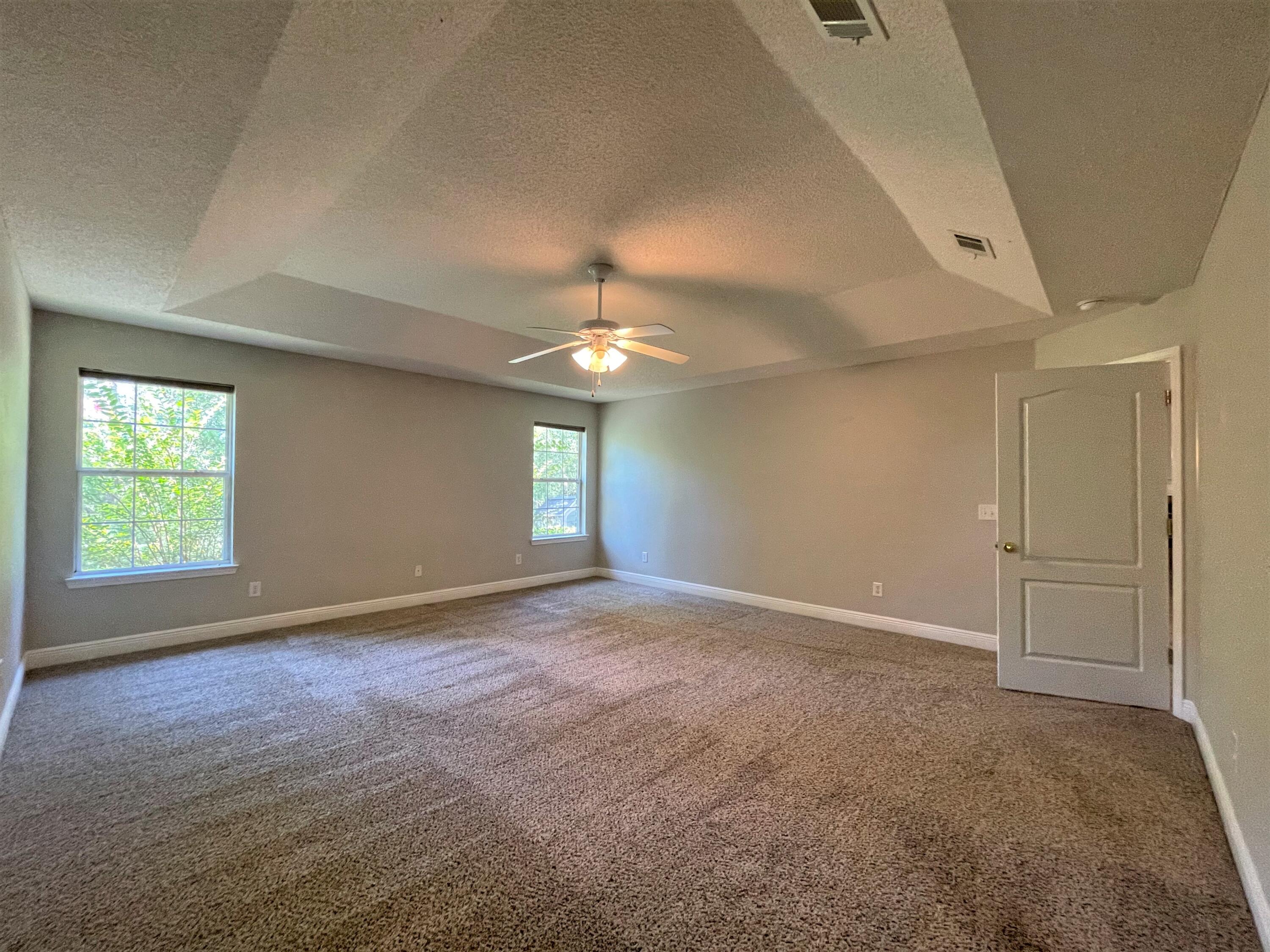 711 Fennec Fox Preserve Crestview, FL 32536 - Photo 16 of 33 an empty room with windows and chandelier fan