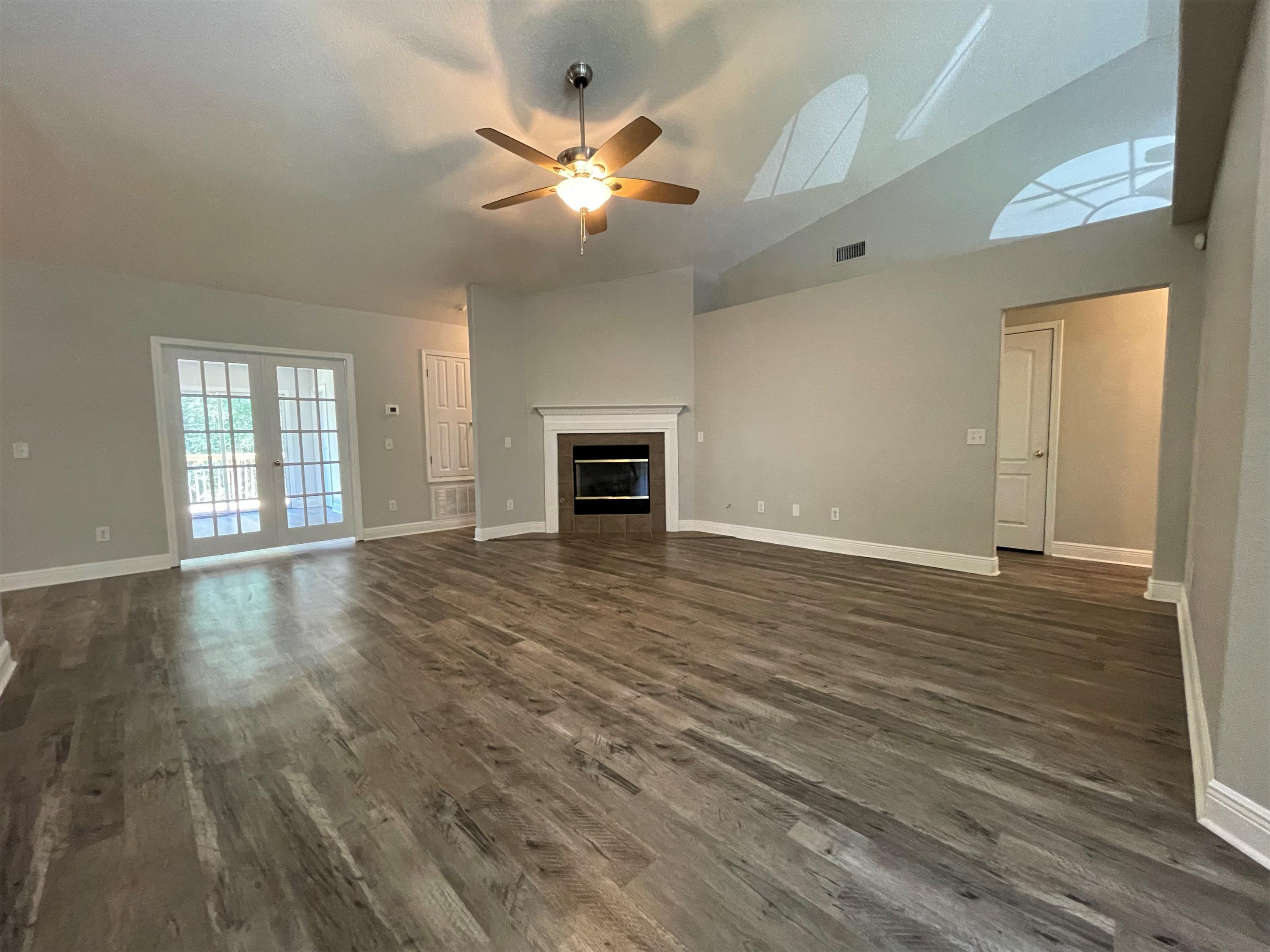 711 Fennec Fox Preserve Crestview, FL 32536 - Photo 2 of 33 an empty room with wooden floor fan and windows