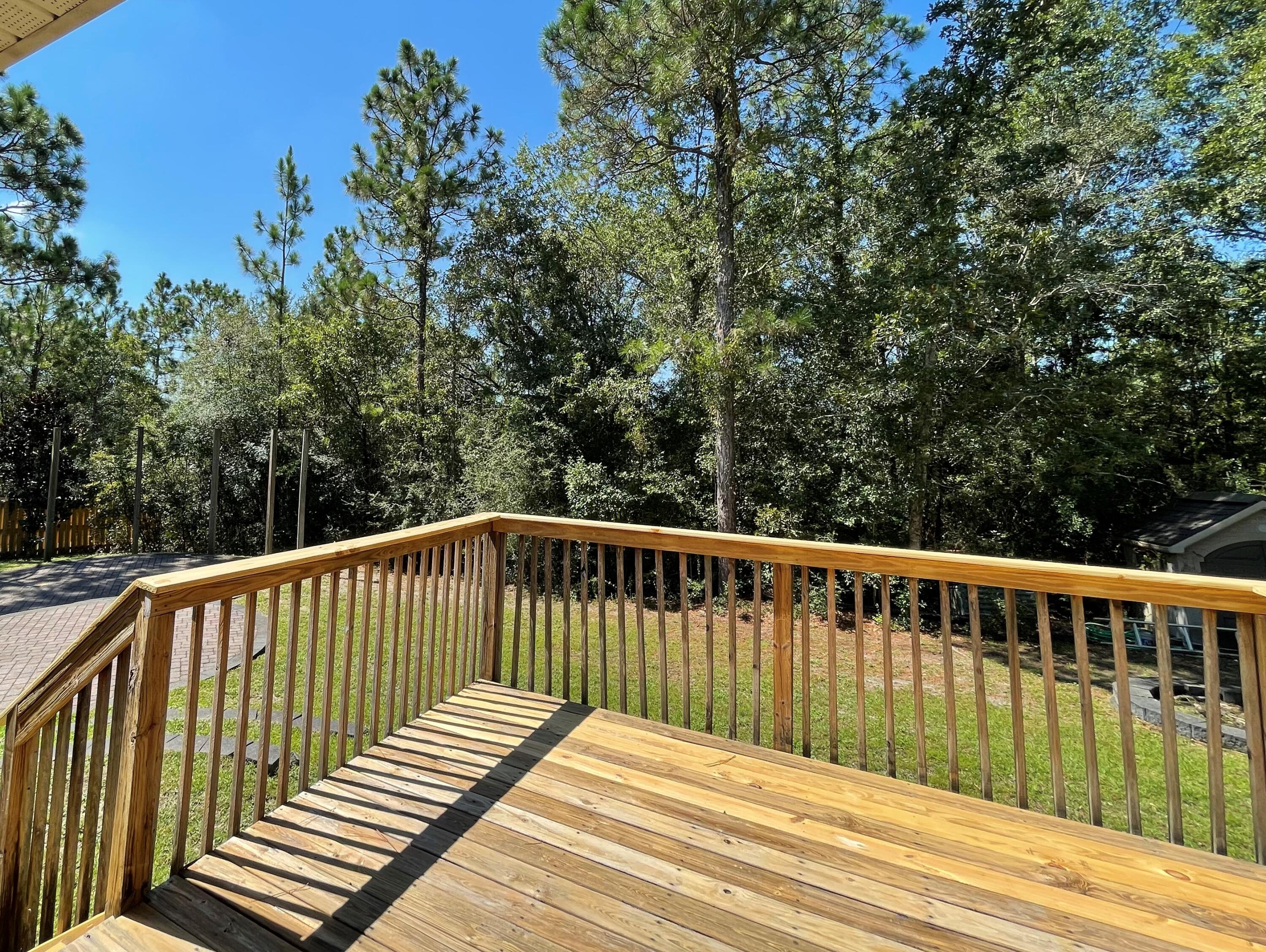 711 Fennec Fox Preserve Crestview, FL 32536 - Photo 29 of 33 a balcony with wooden floor and trees in the background