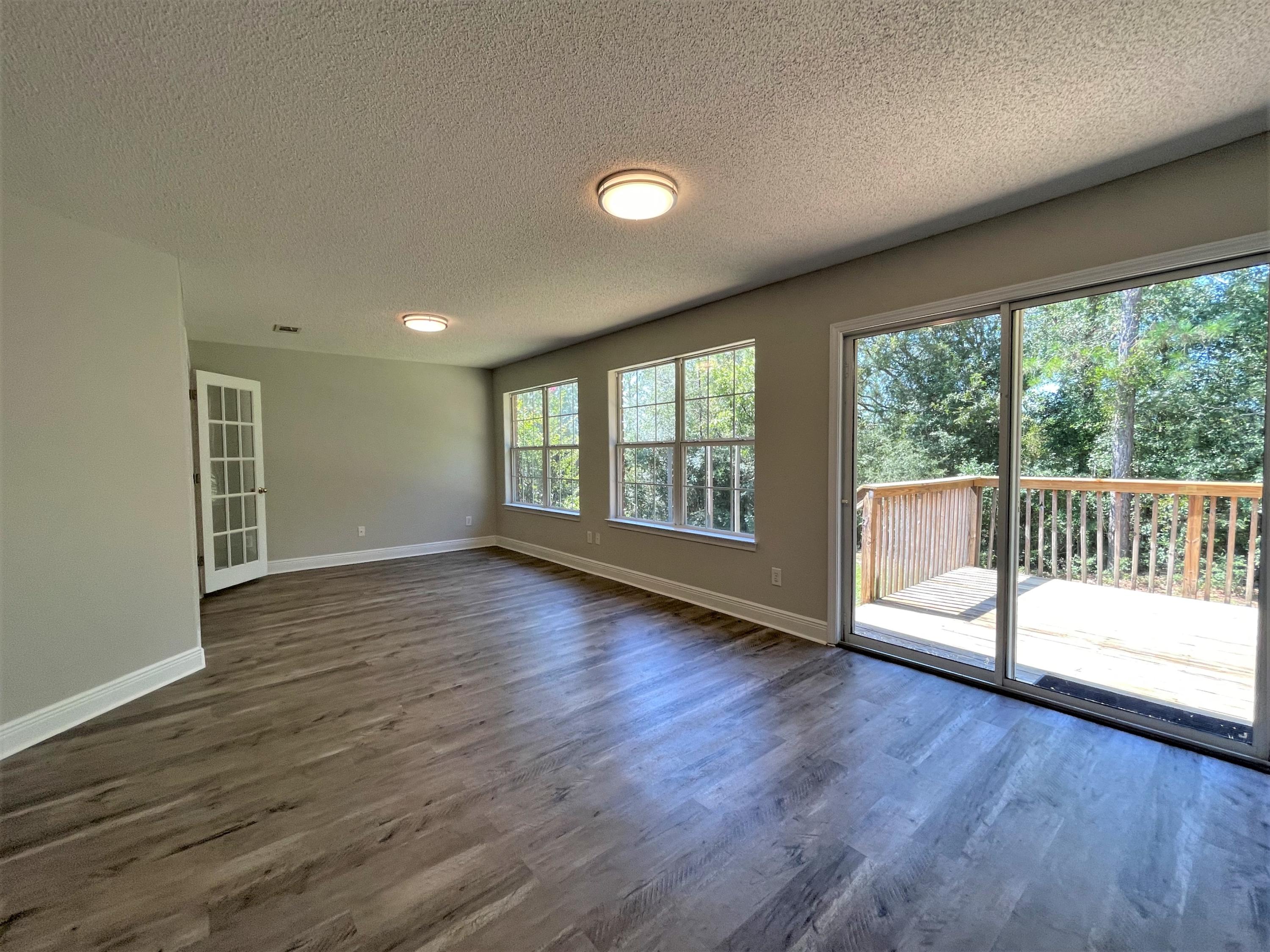 711 Fennec Fox Preserve Crestview, FL 32536 - Photo 7 of 33 an empty room with wooden floor and windows