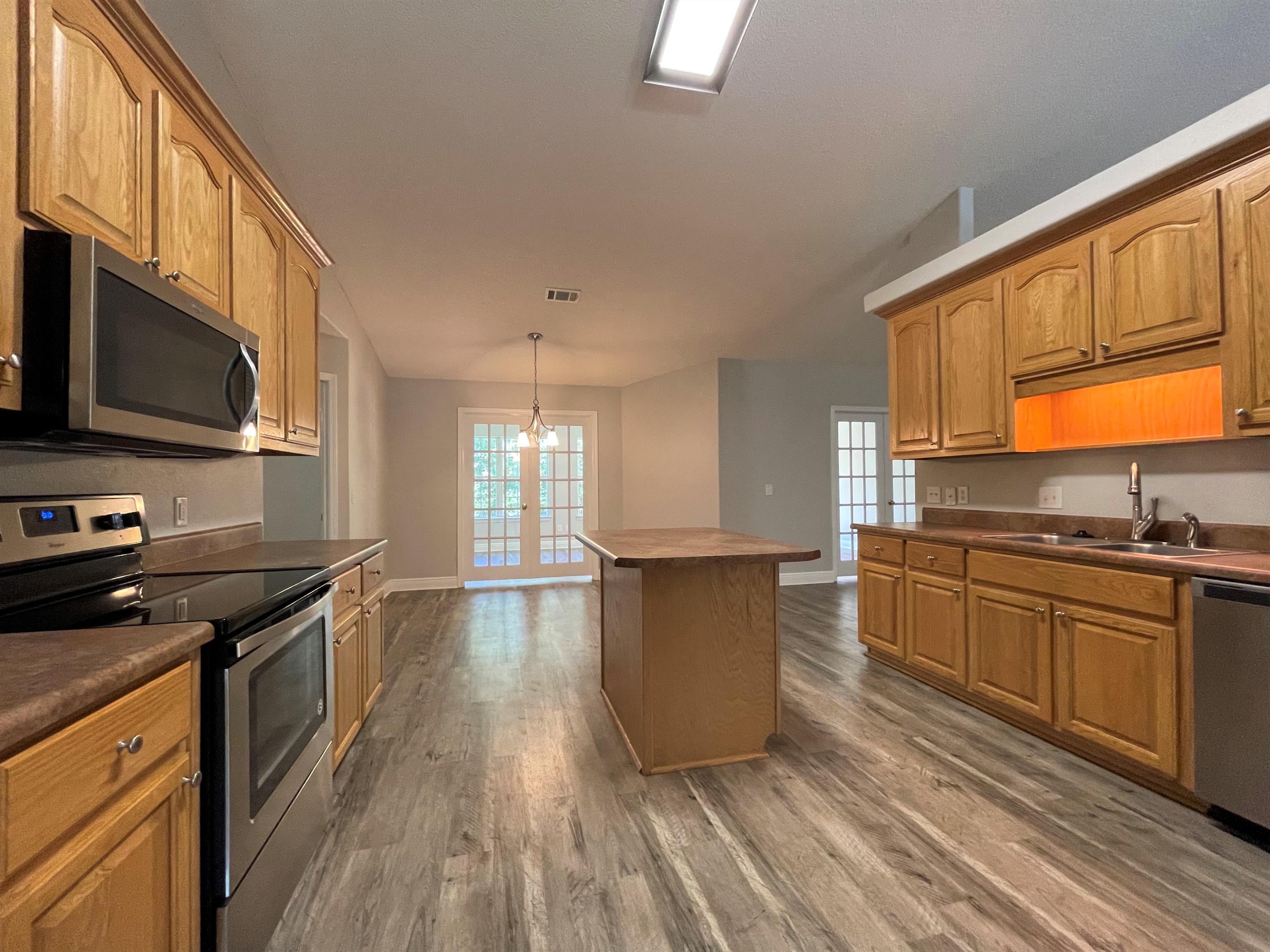 711 Fennec Fox Preserve Crestview, FL 32536 - Photo 10 of 33 a kitchen with stainless steel appliances granite countertop a stove a sink and a microwave