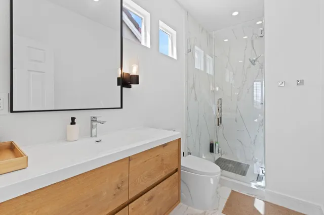 a bathroom with a sink a toilet and shower