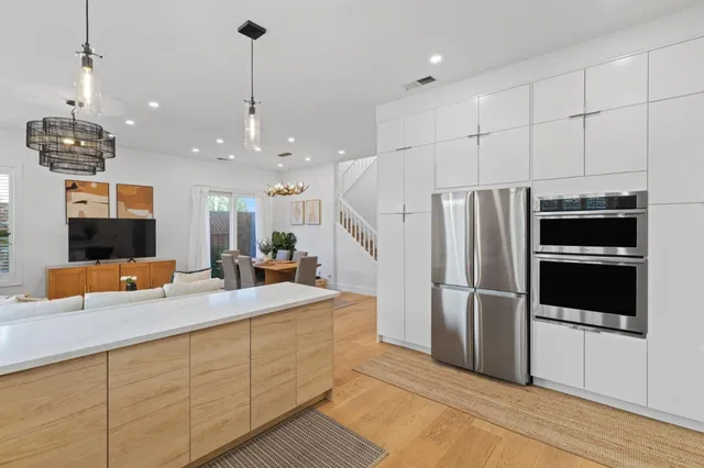 a kitchen with stainless steel appliances kitchen island granite countertop a refrigerator a sink and a stove