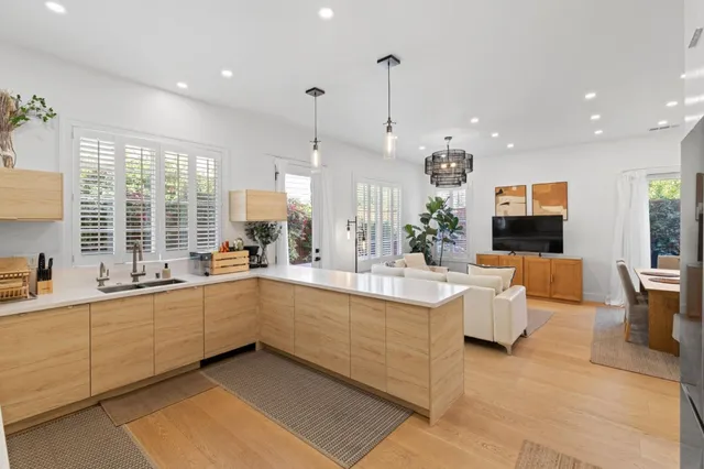 a large white kitchen with a large window and stainless steel appliances