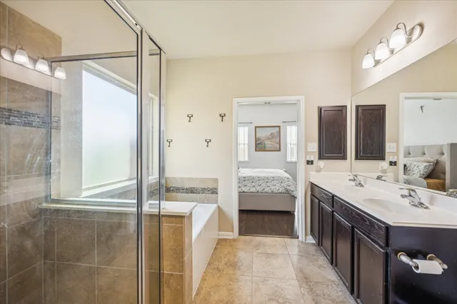 a bathroom with a double vanity sink mirror and bathtub
