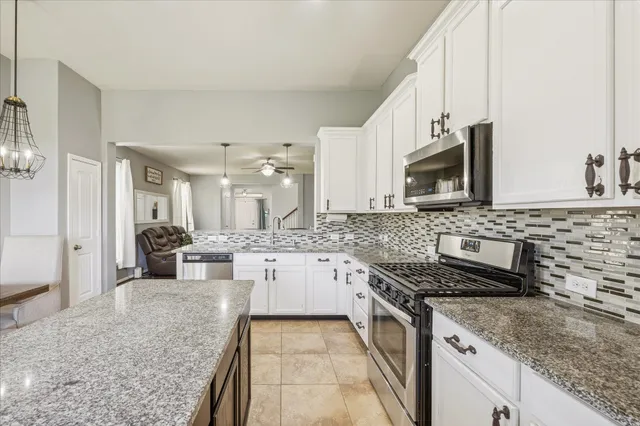 a kitchen with stainless steel appliances granite countertop a sink stove and cabinets