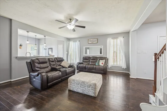a living room with furniture and a wooden floor