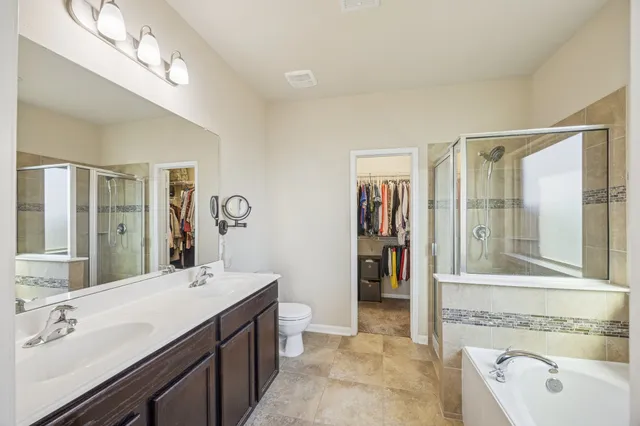 a spacious bathroom with a tub sink and mirror
