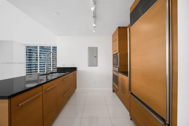 a kitchen with stainless steel appliances granite countertop a refrigerator and a sink