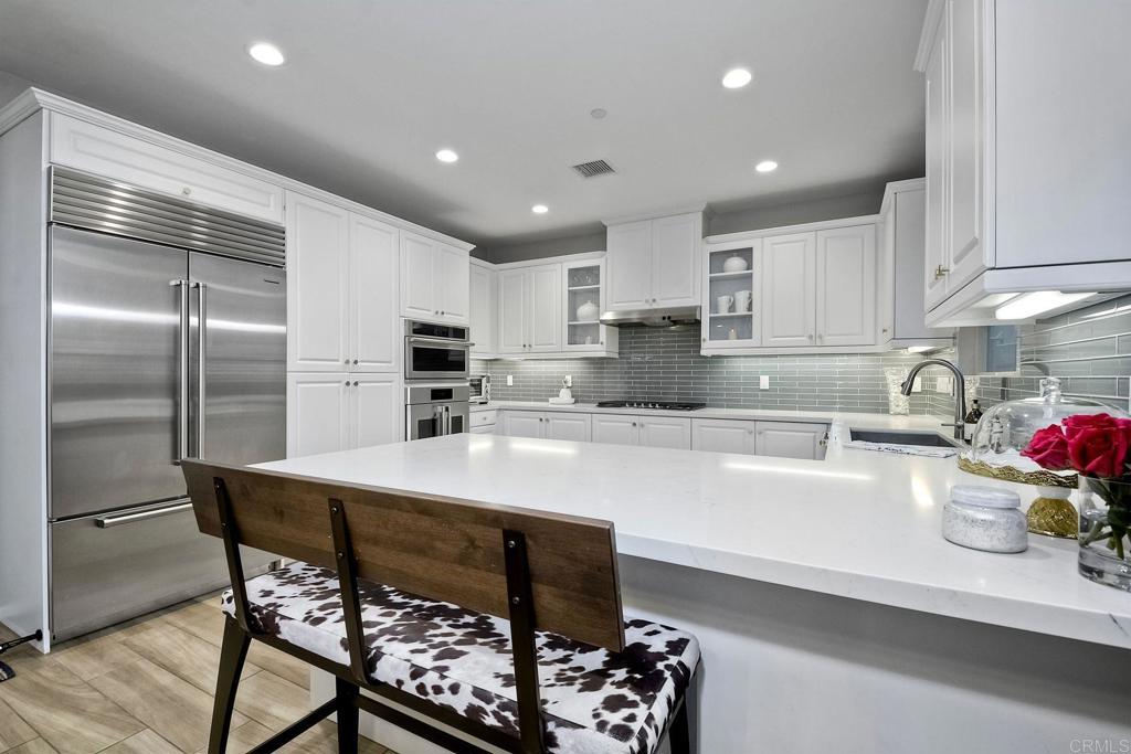 663 Gemstone Drive San Marcos, CA 92078 - Photo 11 of 38 a kitchen with a table chairs refrigerator and cabinets
