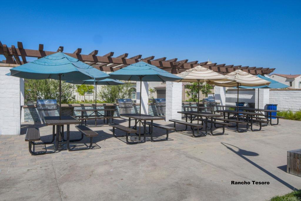 663 Gemstone Drive San Marcos, CA 92078 - Photo 33 of 38 a view of a patio with a table and chairs under an umbrella