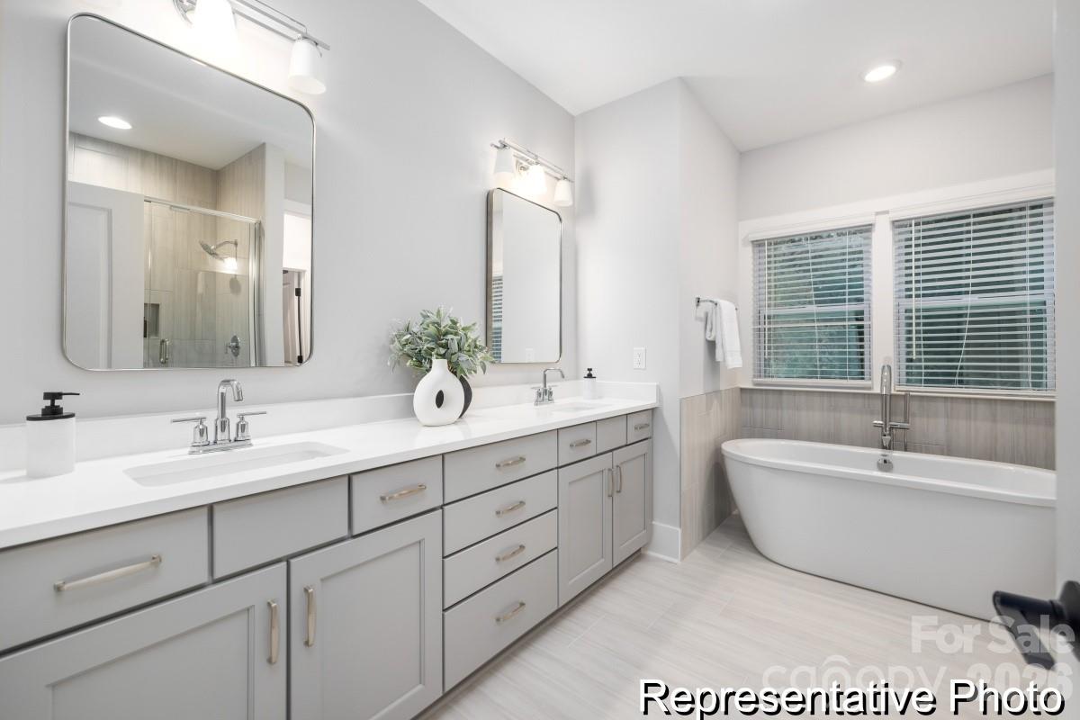 106 West Rice Planters Way, Unit 8P Statesville, NC 28625 - Photo 23 of 35 a spacious bathroom with a double vanity sink mirror and bathtub