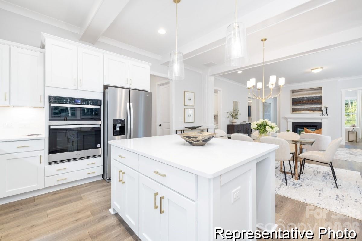106 West Rice Planters Way, Unit 8P Statesville, NC 28625 - Photo 5 of 35 a large kitchen with kitchen island a sink table and chairs