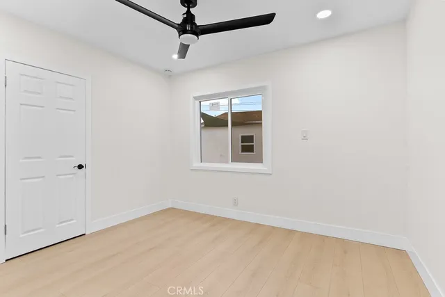 an empty room with a window and a ceiling fan
