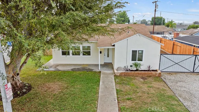 a front view of a house with a yard and potted plants