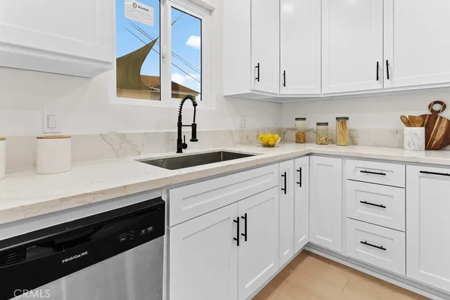 a kitchen with white cabinets and sink