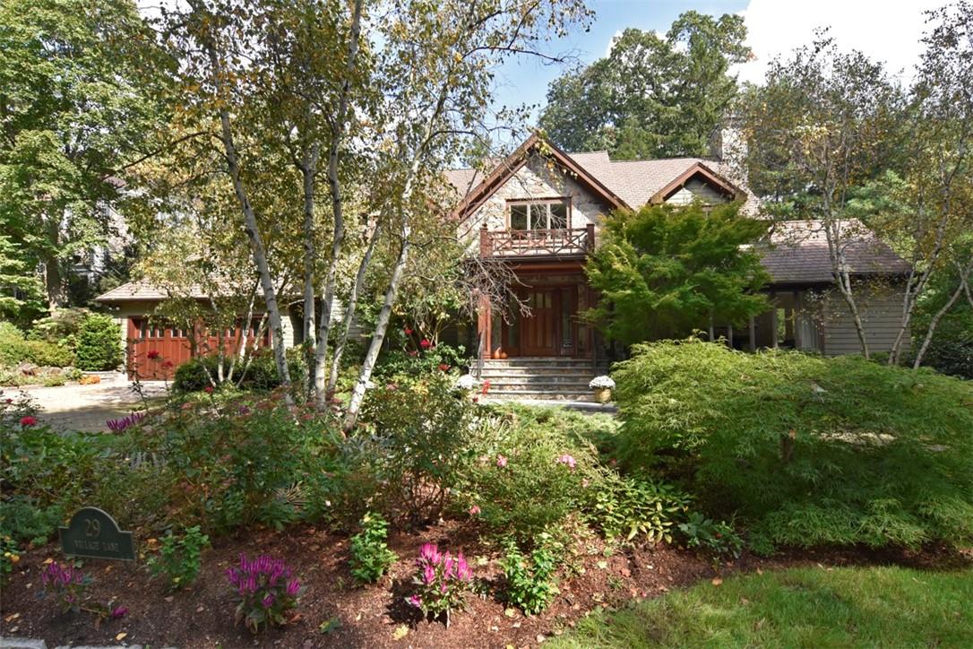 a front view of a house with a yard and trees