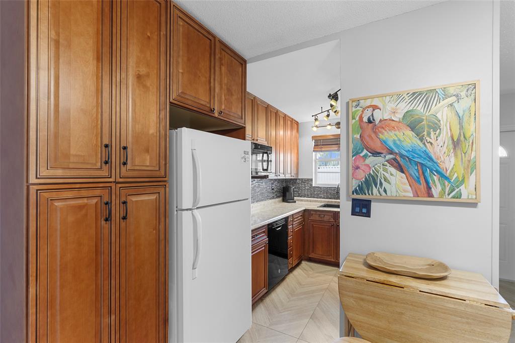 30 Southeast 13th Street, Unit A6 Boca Raton, FL 33432 - Photo 5 of 30 a white refrigerator freezer and a stove sitting inside of a kitchen