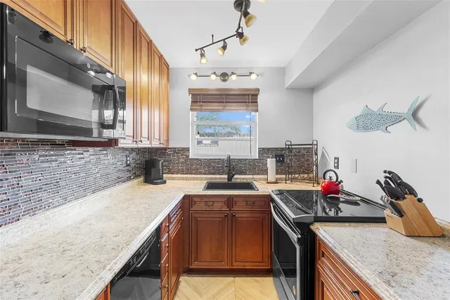 a kitchen with stainless steel appliances granite countertop a sink stove and cabinets