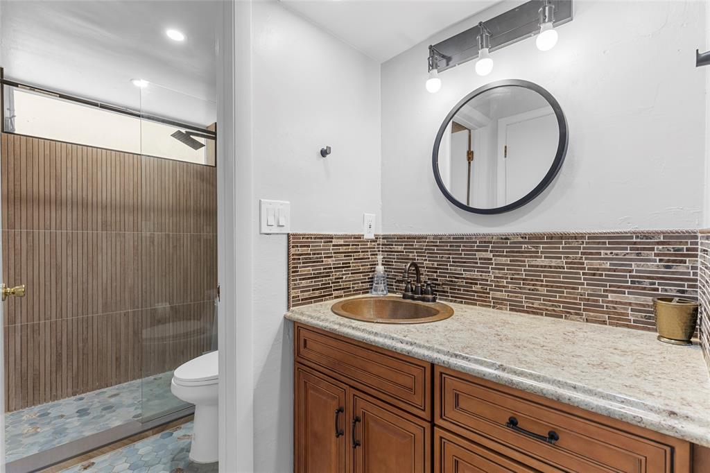 30 Southeast 13th Street, Unit A6 Boca Raton, FL 33432 - Photo 9 of 30 a bathroom with a granite countertop toilet a sink and a mirror
