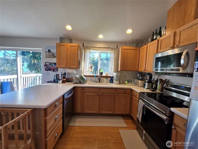 a kitchen with stainless steel appliances granite countertop a sink stove and microwave