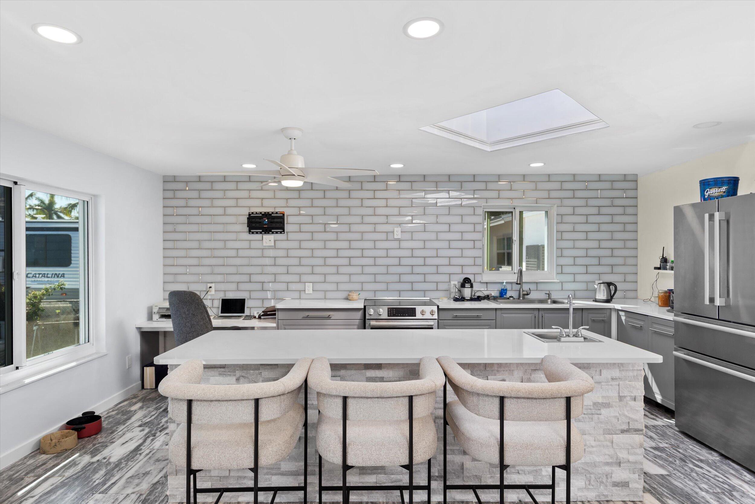 2924 Riviera Drive Key West, FL 33040 - Photo 2 of 43 a kitchen with stainless steel appliances kitchen island granite countertop a sink and chairs