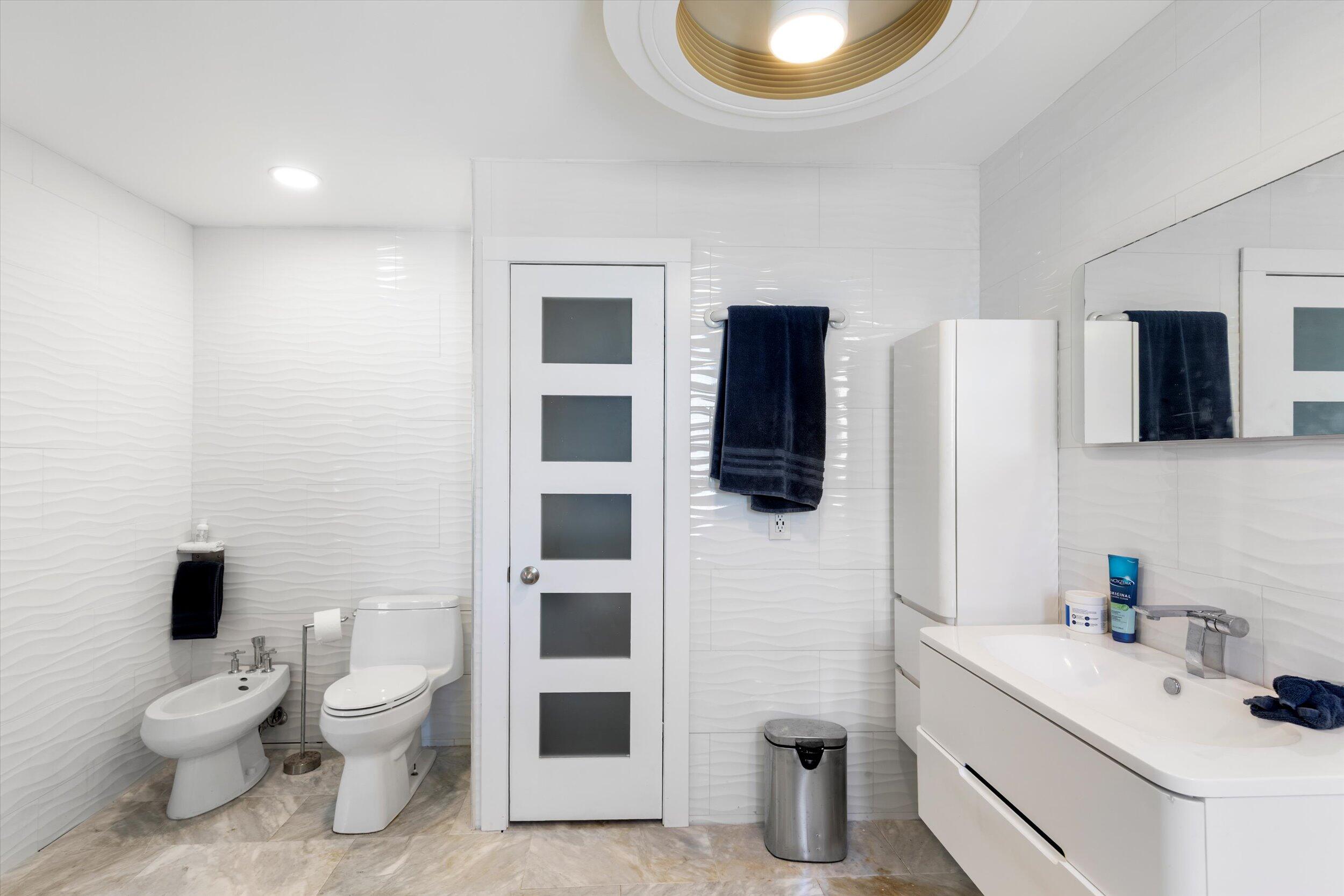 2924 Riviera Drive Key West, FL 33040 - Photo 38 of 43 a bathroom with a toilet sink a shower and mirror