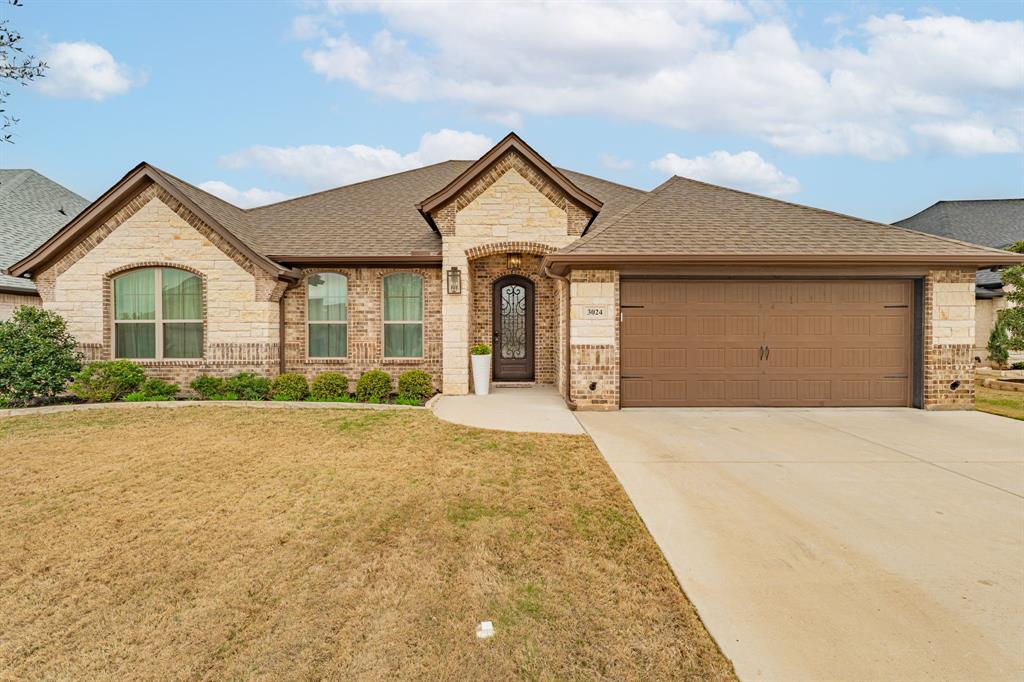 3024 Reed Court Granbury, TX 76048 - Photo 1 of 40 a front view of a house with a yard and garage