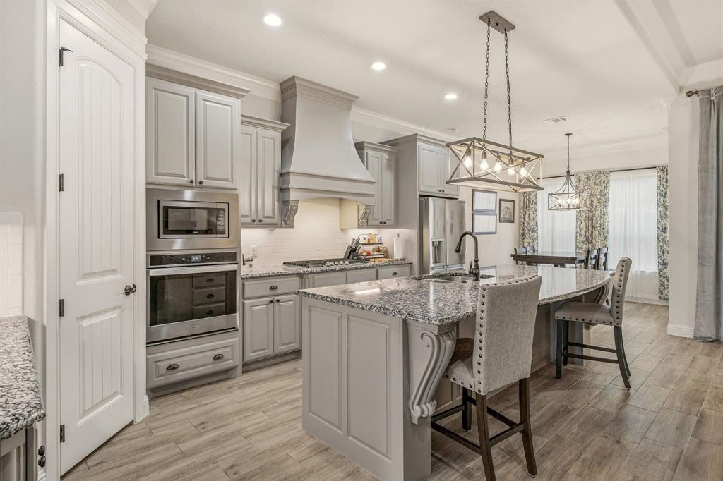 3024 Reed Court Granbury, TX 76048 - Photo 12 of 40 a kitchen with stainless steel appliances granite countertop a stove and white cabinets