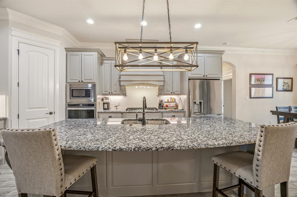 3024 Reed Court Granbury, TX 76048 - Photo 13 of 40 a kitchen with kitchen island granite countertop a table and chairs in it