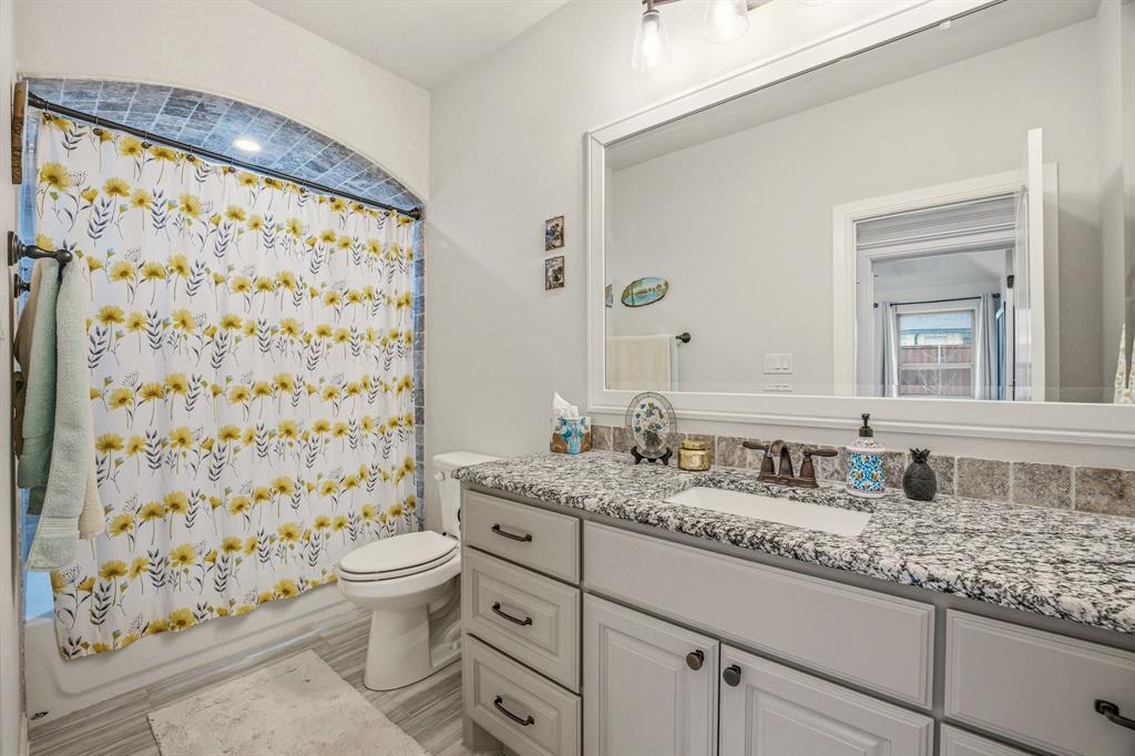 3024 Reed Court Granbury, TX 76048 - Photo 15 of 40 a bathroom with a granite countertop sink a toilet and a shower