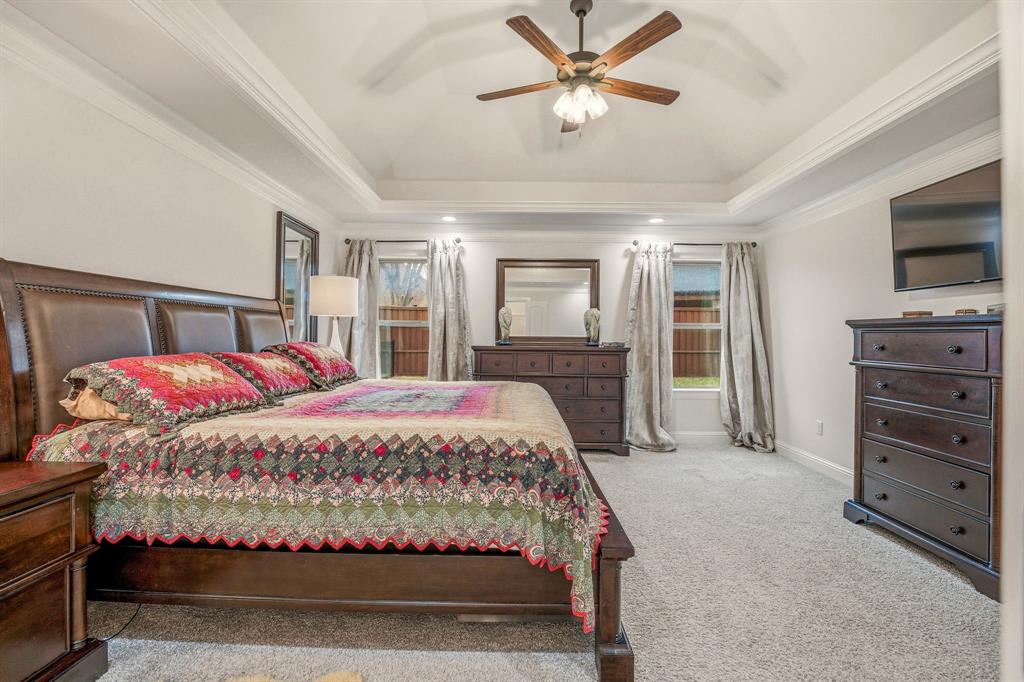 3024 Reed Court Granbury, TX 76048 - Photo 19 of 40 a bedroom with a large bed and a chandelier