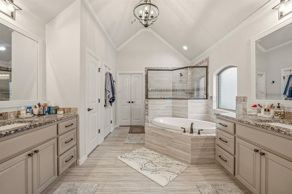 3024 Reed Court Granbury, TX 76048 - Photo 20 of 40 a bathroom with a double vanity sink a toilet a mirror and bathtub