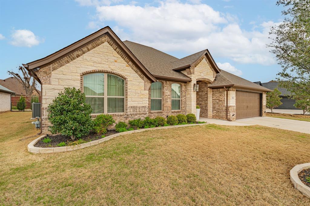 3024 Reed Court Granbury, TX 76048 - Photo 2 of 40 a front view of a house with a yard and garage