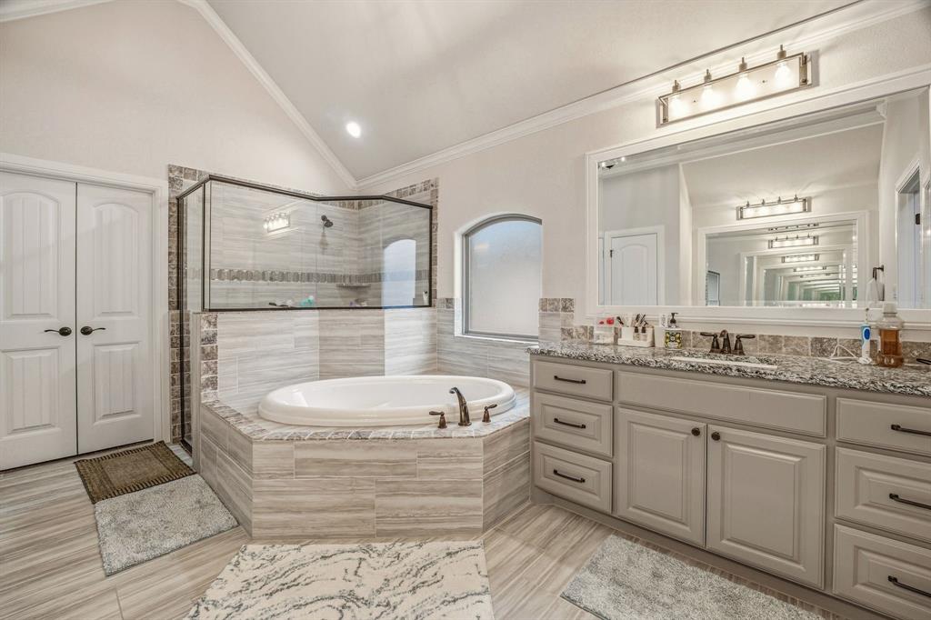 3024 Reed Court Granbury, TX 76048 - Photo 21 of 40 a spacious bathroom with a double vanity sink a mirror and a bathtub