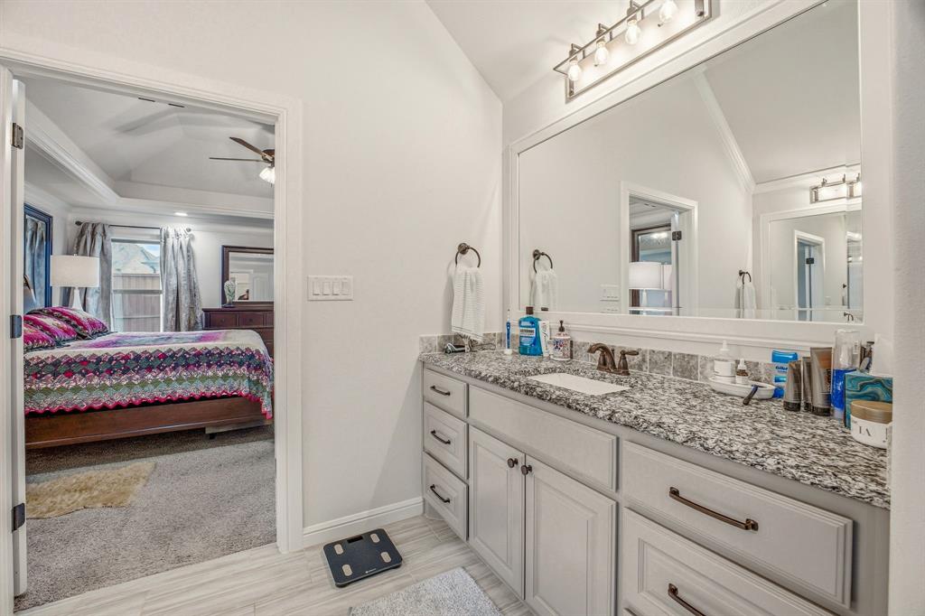 3024 Reed Court Granbury, TX 76048 - Photo 22 of 40 a en suite bathroom with a granite countertop sink and a mirror