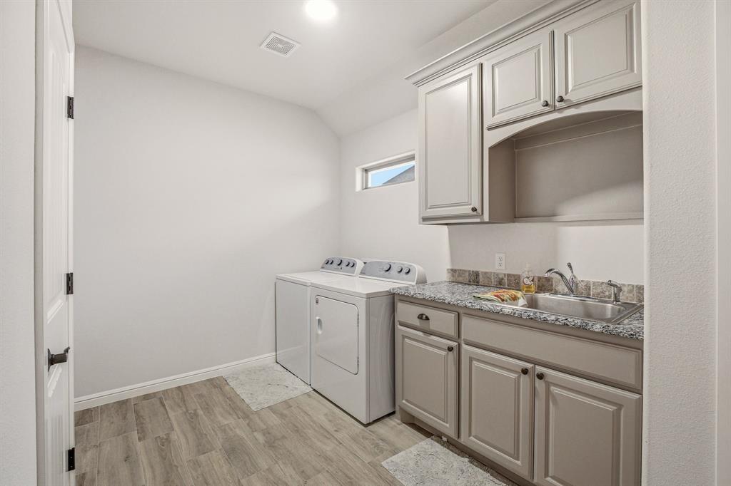 3024 Reed Court Granbury, TX 76048 - Photo 28 of 40 a kitchen with a sink cabinets and a wooden floor