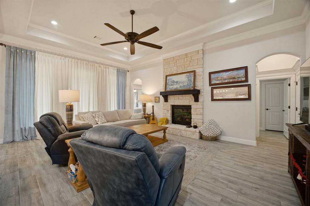 3024 Reed Court Granbury, TX 76048 - Photo 7 of 40 a living room with furniture a fireplace and a flat screen tv