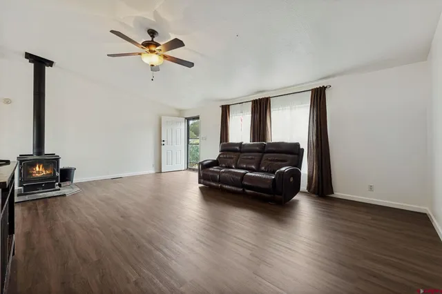 a living room with couches and a flat screen tv with wooden floor