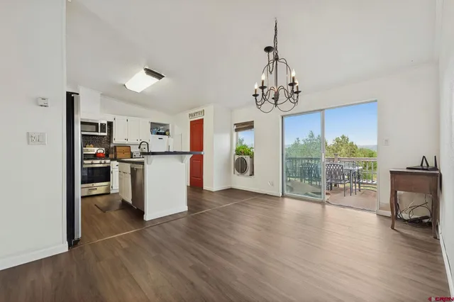 a view of a kitchen with furniture and wooden floor