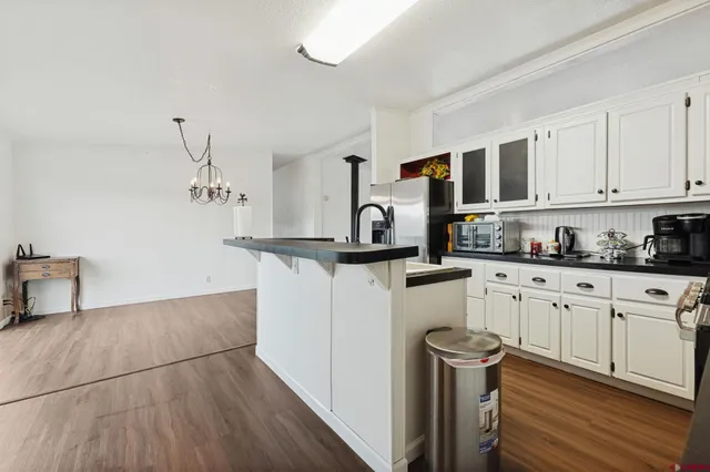 a kitchen with stainless steel appliances granite countertop a refrigerator sink and white cabinets