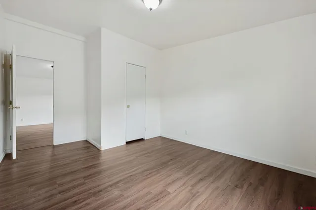 a view of an empty room with wooden floor